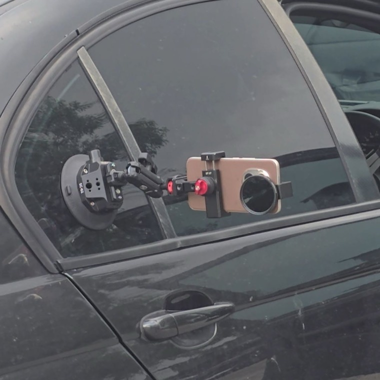 A phone clamped to a car window ready to shoot