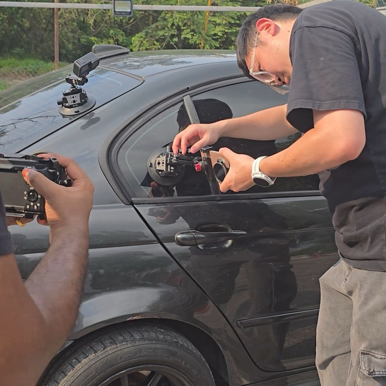 Crew mounting a phone rig to a car window