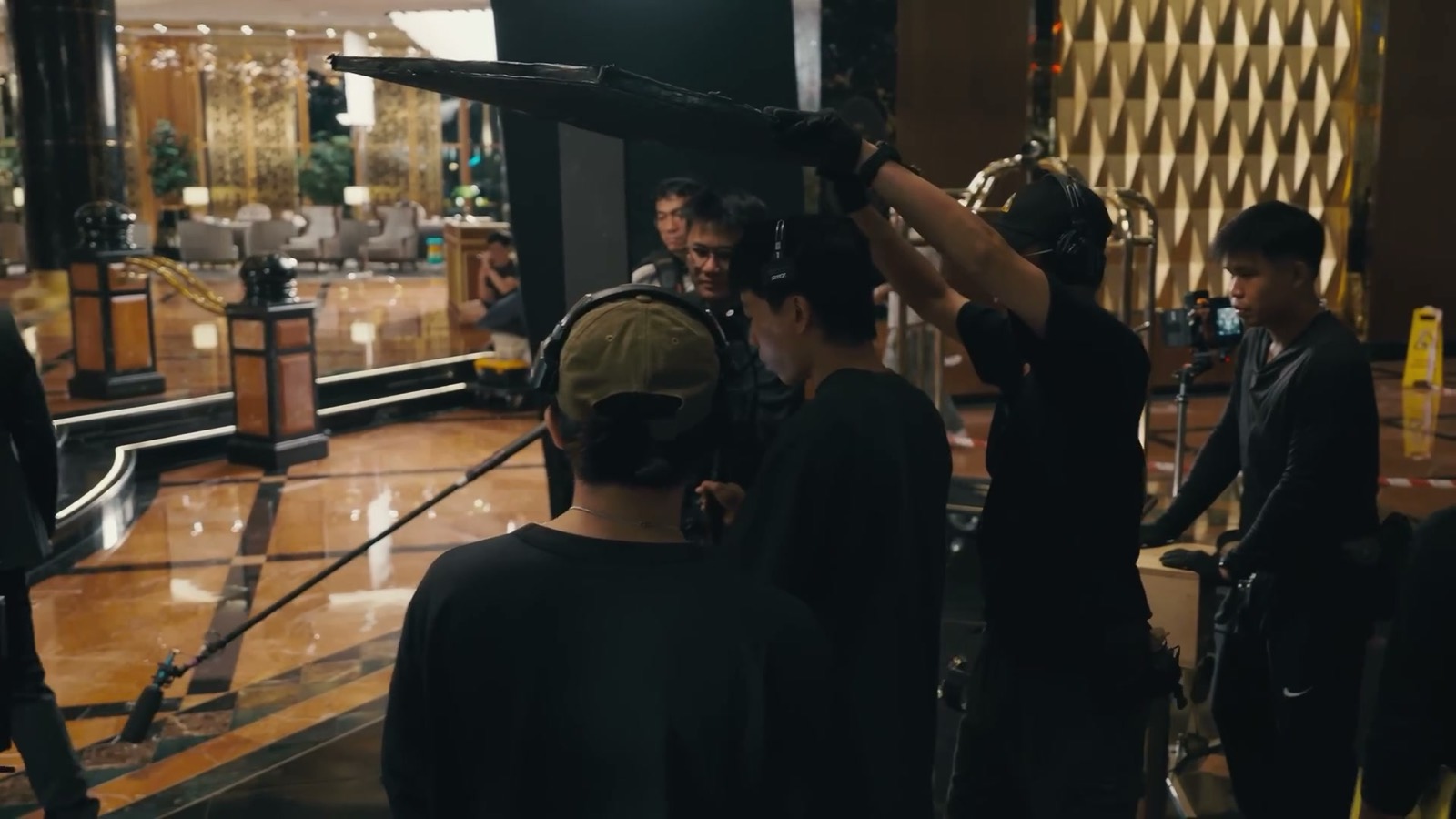 Our crew on location with boom and monitors, shooting in a hotel lobby