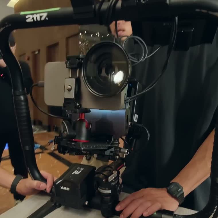 A phone built into a full cinema camera rig, operator hands on the bars